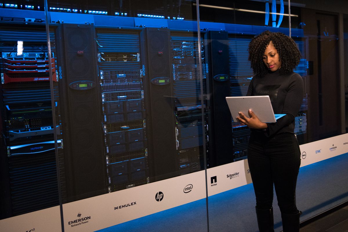 Engineer with a laptop performing maintenance in a data center